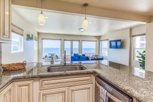 a kitchen with a sink and a view of the ocean at Ocean Beach Cliffs Sanctuary Oceanfront cottage w/unobstructed views & deck: steps to the water in San Diego