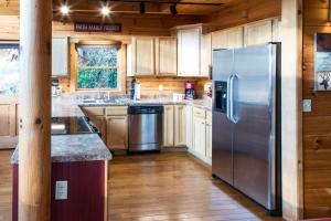 eine Küche mit einem Kühlschrank aus Edelstahl und Holzschränken in der Unterkunft 4 Bed 4 Bath Vacation home in Sylva I in Sylva