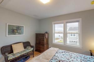 a bedroom with a bed and a chair and a window at Bella Luna in Falmouth