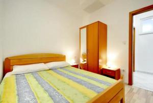 a bedroom with a bed with a yellow and blue blanket at Apartment SImun in Podgora
