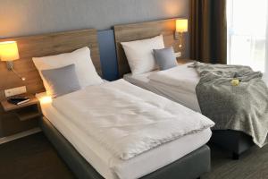 duas camas num quarto de hotel ao lado um do outro em StadtHotel ARTE em Remagen