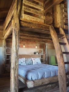 sypialnia z dużym łóżkiem w drewnianym domku w obiekcie Virasol w mieście Dronero