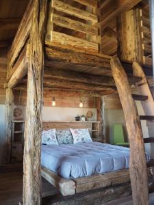 a bedroom with a large bed in a log cabin at Virasol in Dronero