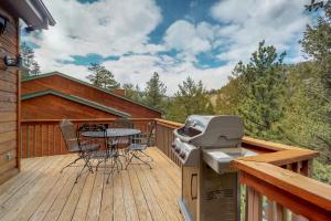 um deque com comodidades para churrascos, uma mesa e cadeiras em Mountain Splendor em Estes Park