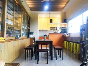 a dining room with a table and stools at Mr. Sloth & Mrs. Cat B&B in Taitung City