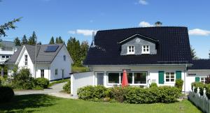 ein weißes Haus mit schwarzem Dach in der Unterkunft Schneekäppchen 1 in Winterberg