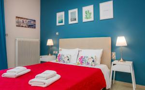a bedroom with a red bed with towels on it at Central Thassos Apartment 3 in Limenas
