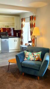 a living room with a blue couch and a kitchen at 20 Market Place Coleford in Coleford