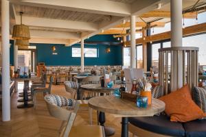 a restaurant with tables and chairs and a couch at Oystercatcher Apartments in Polzeath +37 photos