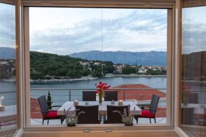 een raam met uitzicht op een tafel en stoelen bij Apartment Puntinak in Selca