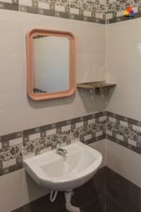 a bathroom with a sink and a mirror on the wall at Trippr Kodaikanal Backpacker Hostel in Kodaikānāl