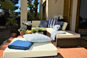 a patio with two couches and pillows on a porch at Villa Sitges Colibri at 10 min Walk Beaches - Center City Amaizing Garden Pool XXL Private Tenis Piste in Vilanova i la Geltrú
