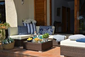 a patio with wicker chairs and a table with fruit at Villa Sitges Colibri at 10 min Walk Beaches - Center City Amaizing Garden Pool XXL Private Tenis Piste in Vilanova i la Geltrú