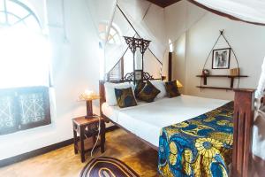 ein Schlafzimmer mit einem Bett in einem Zimmer in der Unterkunft The Swahili House in Zanzibar City