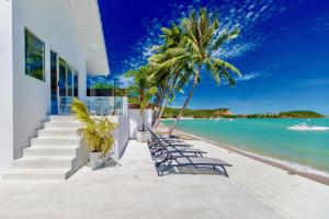 a row of chairs on the beach near a house at So KohKoon Beach Resort in Bang Rak Beach