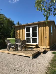 a cabin with chairs and a table on a deck at Camping Porte des Vosges in Bulgnéville