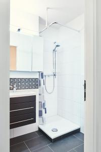 een witte badkamer met douche en wastafel bij Gemütlich - Mountainbike - Pool & Sauna - Netflix in Winterberg +8 foto's