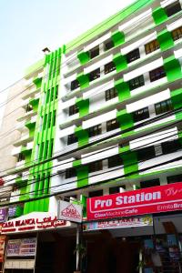 wysoki zielony i biały budynek z znakami przed nim w obiekcie Casa Blanca Apartment w mieście Manila