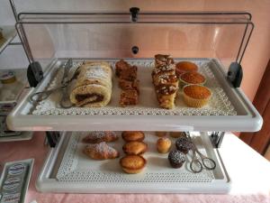 a display case filled with different types of pastries and muffins at Podere San Luigi Residence in Otranto