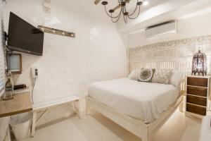 a bedroom with a bed and a flat screen tv at Lugar Bonito Hotel in Boracay