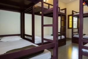 a room with four bunk beds in it at Trippr Kodaikanal Backpacker Hostel in Kodaikānāl