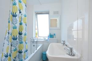 a bathroom with a sink and a shower curtain at London Deluxe Four Bedroom House in Dagenham +35 photos