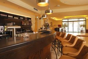 eine Bar in einem Restaurant mit braunen Ledersesseln in der Unterkunft Farmer Hotel Basedow in Basedow