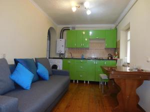 sala de estar con sofá y cocina con armarios verdes en пл Ленина 20 курзона центр, en Pyatigorsk