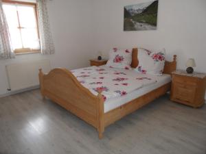 a bedroom with a wooden bed with flowers on it at Ferienwohnung Engelhardt in Oberreute