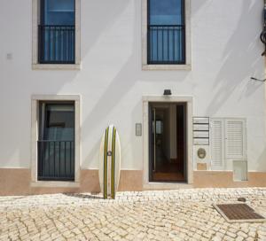 a white building with a yellow refrigerator in front of it at Pedra Branca Apartments in Ericeira