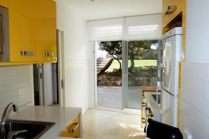 a kitchen with a sink and a refrigerator at Villa Terra in Cala en Blanes