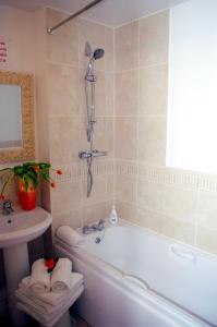 Ladysmith House - 4 Bedrooms - Full House في غريمسبي: حمام مع حوض استحمام ومغسلة