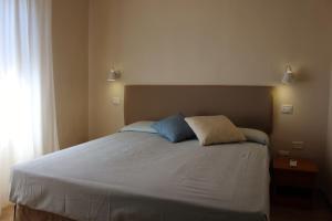 a bed with two pillows on it in a bedroom at Hotel Ristorante Il Gabbiano in Cecina