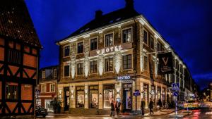 Un edificio all'angolo di una strada con persone che stanno fuori di V Hotel Helsingborg; BW Premier Collection a Helsingborg