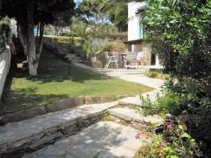 a garden with a stone path and a table and chairs at Blue Dolphin in Batsi