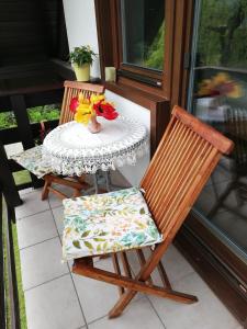 einen Tisch und Stühle auf einer Veranda mit einem Tisch in der Unterkunft Apartment Mlakar in Bohinj
