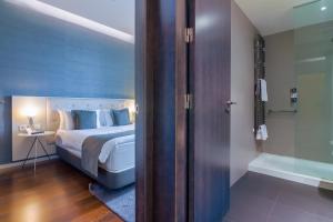 a bedroom with a bed and a bathroom with a tub at Hotel Cismigiu in Bucharest