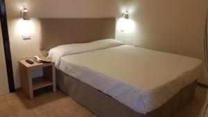 a hotel room with a bed and a phone on a table at Hotel Ristorante Il Gabbiano in Cecina