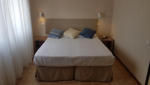 a bedroom with a large bed with blue pillows at Hotel Ristorante Il Gabbiano in Cecina