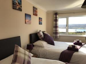 a bedroom with two beds and a window at Corran House in Kingsburgh