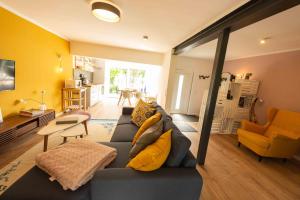 sala de estar con sofá azul y almohadas amarillas en kleineHauszeit das Ferienhaus am Grimnitzsee, en Joachimsthal