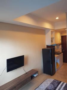 Habitación con TV en la pared en Capitol Park Residence salemba-cozy room en Yakarta