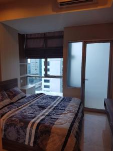 a bedroom with a large bed and a large window at Capitol Park Residence salemba-cozy room in Jakarta