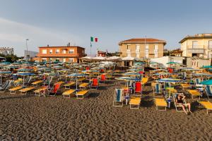 a bunch of chairs and umbrellas on a beach at Hotel Ristorante Il Gabbiano in Cecina