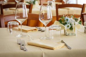 a table with wine glasses and napkins on it at Hotel Ristorante Il Gabbiano in Cecina