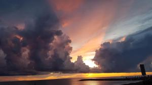 a cloudy sky over the ocean with the sun setting at Hotel Ristorante Il Gabbiano in Cecina