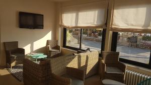 a living room with a couch and chairs and a tv at Hotel Ristorante Il Gabbiano in Cecina