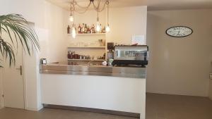 a kitchen with a counter and a clock on the wall at Hotel Ristorante Il Gabbiano in Cecina