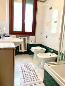 a bathroom with two sinks and a toilet and a tub at Hotel Grand Prix in Sottomarina