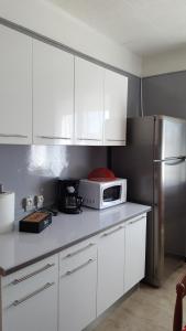 une cuisine avec des armoires blanches et un réfrigérateur en acier inoxydable dans l'établissement Appartement avec terrasse quartier Montplaisir, à Arles